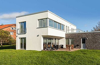 ECO System HAUS – Bauhaus Modern Classic mit weißem Stein, hellen Fenstern, Terrasse und Garten