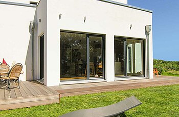 ECO System HAUS – Bauhaus Modern Classic mit weißem Stein und dunklen Fenstern, Gartenansicht