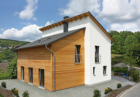 ECO System HAUS – Pultdachhaus mit weißem Stein, Holz und dunklem Dach