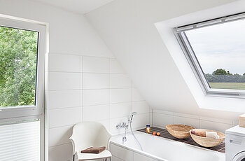 ECO System HAUS – Badezimmer mit braunen Fliesen, Ansicht Badewanne