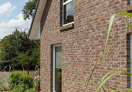ECO System HAUS – Vario-Haus mit rotbraunem Stein und weißen Fenstern