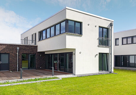 ECO System HAUS – Bauhaus Modern Classic mit weißem und rotbraunem Stein und großer Terrasse mit Garten