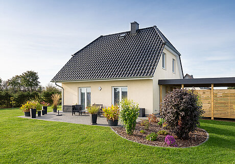 ECO System HAUS – Vario-Haus mit hellem Stein, weißen Fenstern und dunklem Dach