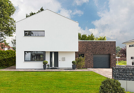 ECO System HAUS – Bauhaus Modern Classic mit weißem und rotbraunem Stein und dunkler Tür, Vorderansicht