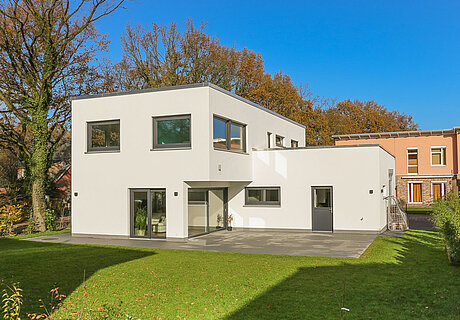 ECO System HAUS – Bauhaus Modern Classic mit hellem Stein und grauen Fenstern, Terrasse mit Garten