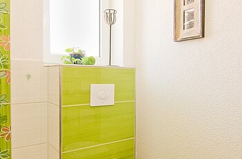 ECO System HAUS – Badezimmer in grün und weiß, Ansicht WC