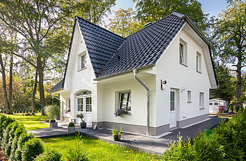 ECO System HAUS – Friesenhaus mit weißem Stein, weißen Fenstern und dunklem Dach