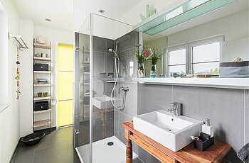 ECO System HAUS – Badezimmer in grau-weiß mit Dusche und Waschbecken