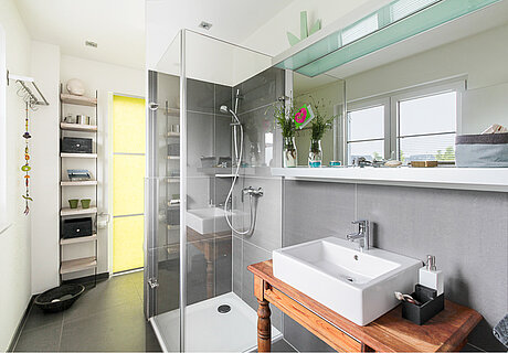 ECO System HAUS – Badezimmer in grau-weiß mit Dusche und Waschbecken