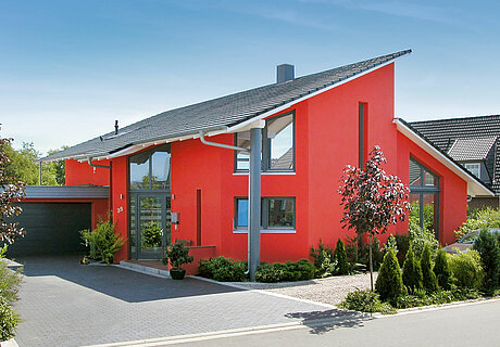 ECO System HAUS – Pultdachhaus mit rotem Stein, dunklem Dach und Garage