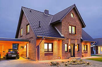 ECO System Haus – Kapitänshaus mit rotem Stein, dunklem Dach und dunklen Fenstern, Vorderansicht