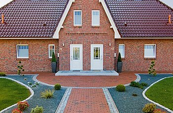 ECO System HAUS – Doppelhaus mit rotem Stein, rotem Dach und hellen Fenstern