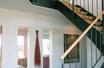 ECO System HAUS – Treppe aus Holz mit dunkelgrauem Geländer
