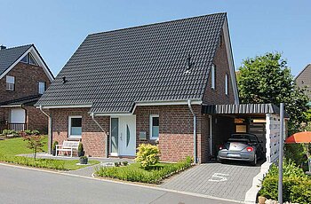ECO System HAUS – Vario-Haus mit hellrotem Stein, dunklem Dach, weißer Tür, weißen Fensern und Garage