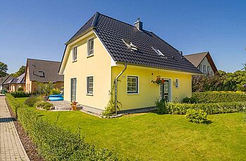 ECO System HAUS – Vario-Haus gelbem Stein, dunklem Dach und Garten