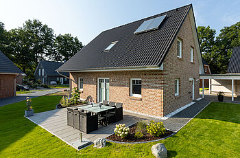 ECO System HAUS – Vario-Haus mit hellrotem Stein, weißen Fenstern und dunklem Dach