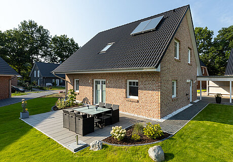ECO System HAUS – Vario-Haus mit hellrotem Stein, weißen Fenstern und dunklem Dach