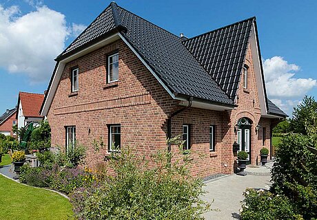 ECO System HAUS – Friesenhaus mit rotem Stein und dunklem Dach