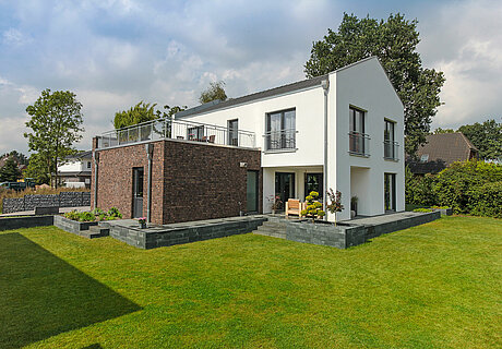 ECO System HAUS – Bauhaus Modern Classic mit weißem und rotbraunem Stein, Gartenansicht
