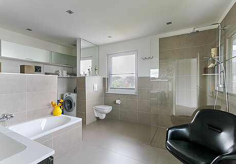 ECO System HAUS – Badezimmer in grau-beige mit Badewanne und Dusche