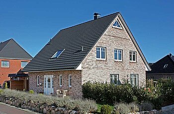 ECO System HAUS – Vario-Haus mit grau-beigem Stein, dunklem Dach und weißen Fenstern