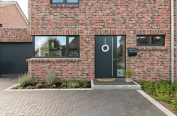 ECO System HAUS – Doppelhaus mit rotem und dunklem Stein und dunkler Tür